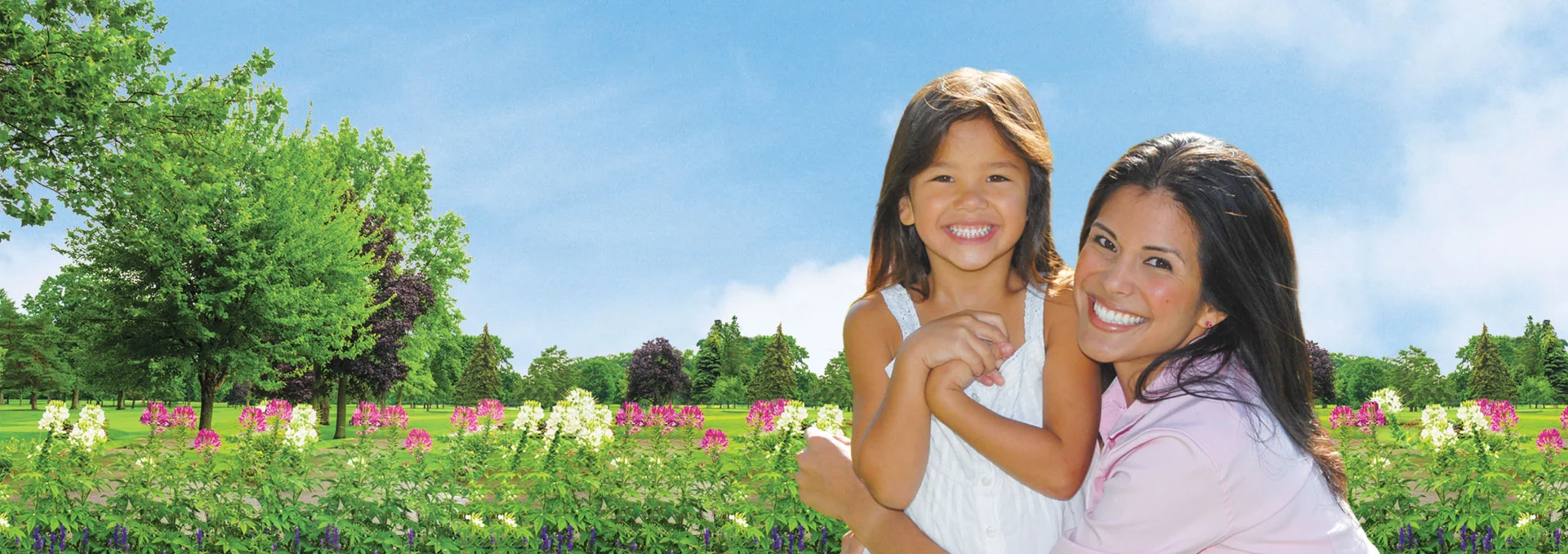 Mother and daughter smiling in a park.
